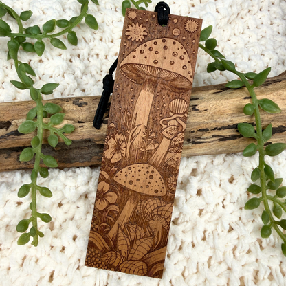 Wooden bookmark with mushroom design on a natural background. Engraved cherry wood