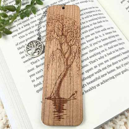 Willow tree wood bookmark with water and a bird design. Sitting on a white book