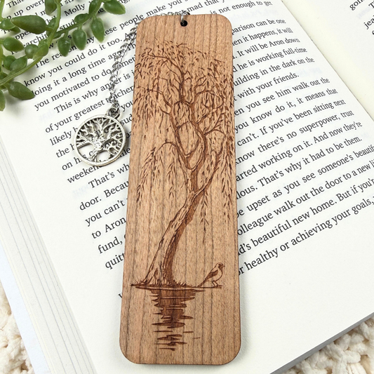 Willow tree wood bookmark with water and a bird design. Sitting on a white book