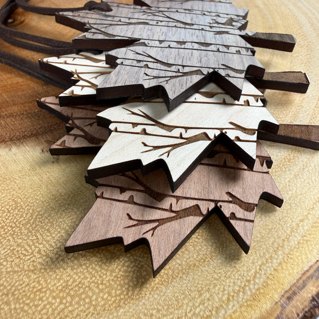 Stack of Canadian maple leaf wood ornaments showing walnut, maple and cherry wood options