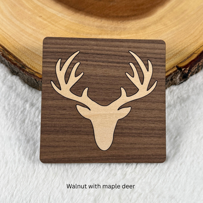 Walnut wood coaster with a maple deer head and antlers inlaid into the surface.