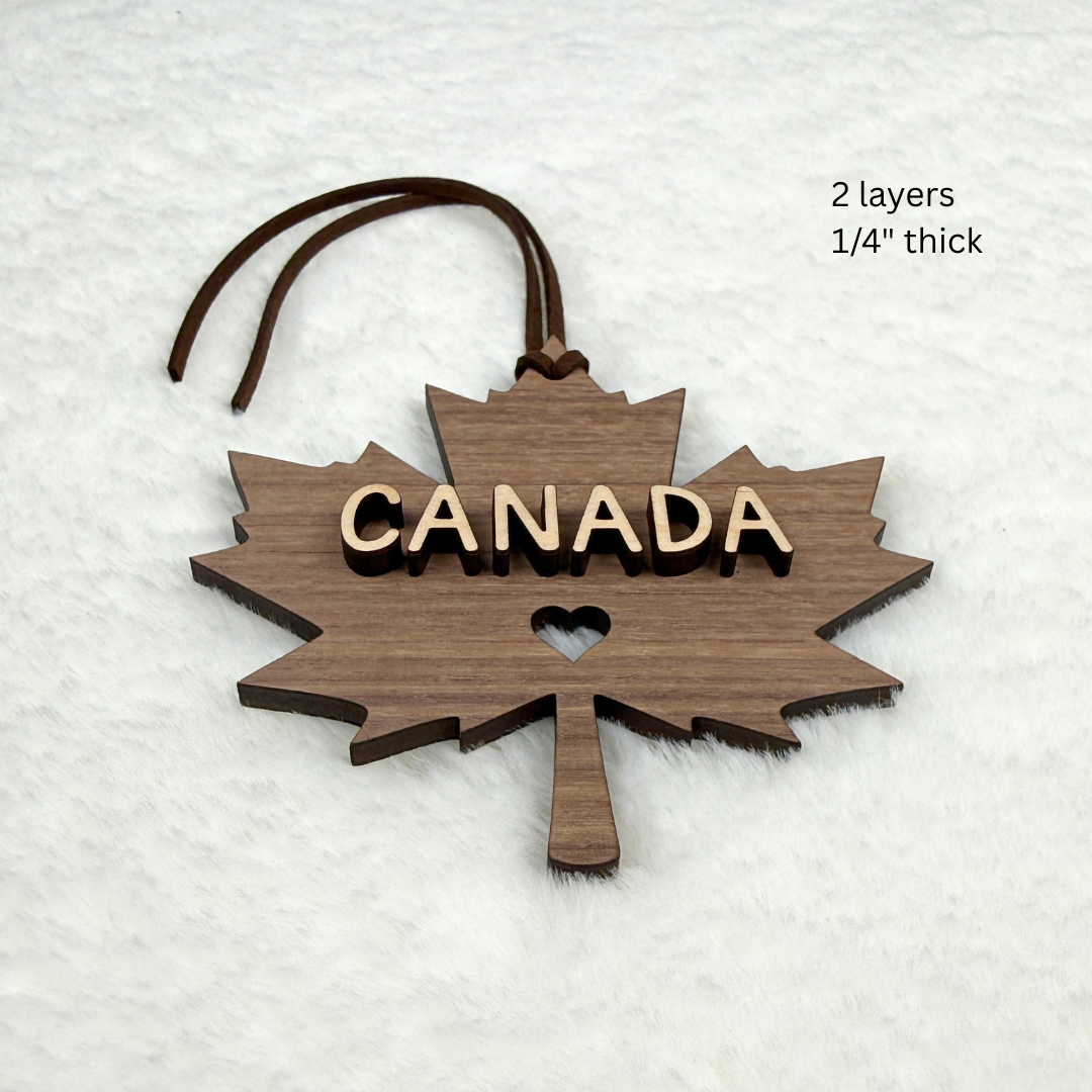 Canada maple leaf wood ornament with brown faux suede hanging rope and heart cutout