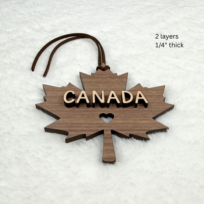 Canada maple leaf wood ornament with brown faux suede hanging rope and heart cutout