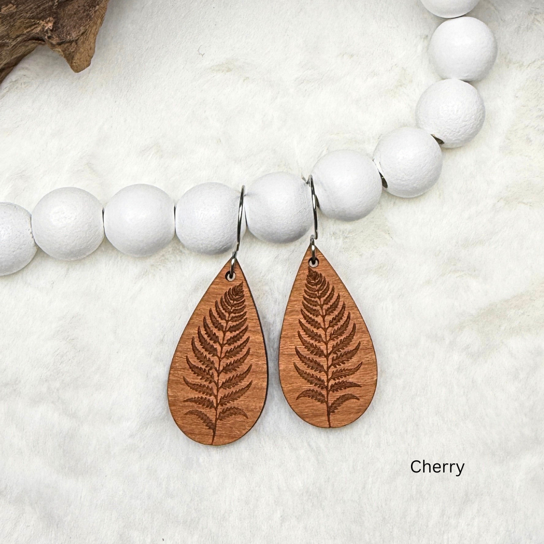 Fern leaf wooden earrings with stainless steel hooks. Finished with vegan wood oil. Laser engraved from cherry wood, handmade in Canada.