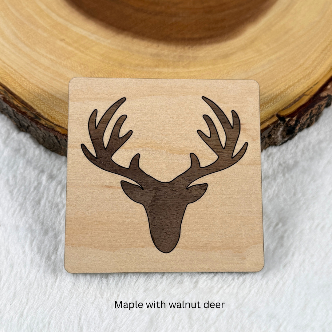 Maple wood coaster with a walnut deer head and antlers inlaid into the surface.