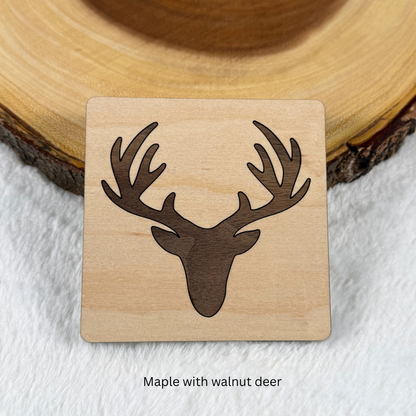 Maple wood coaster with a walnut deer head and antlers inlaid into the surface.