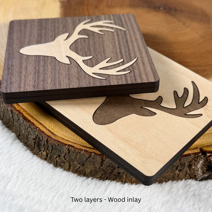 Angled view of overlapping deer inlay wood coasters showing their layered edges.
