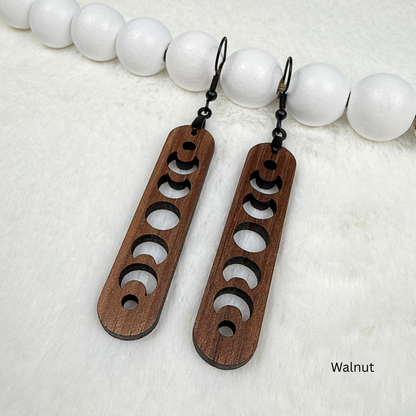 Walnut wood earrings with laser cut crescent moon. Dangle earrings with black stainless steel hooks and silicone backers. Finished with natural wood oil.