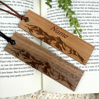 Personalized wooden mountain bookmark in cherry and walnut wood on an open book, nature inspired gift for readers.