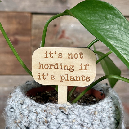 Wooden plant stake sign with the saying "it's not hording if it's plants". Plant decor in a houseplant.