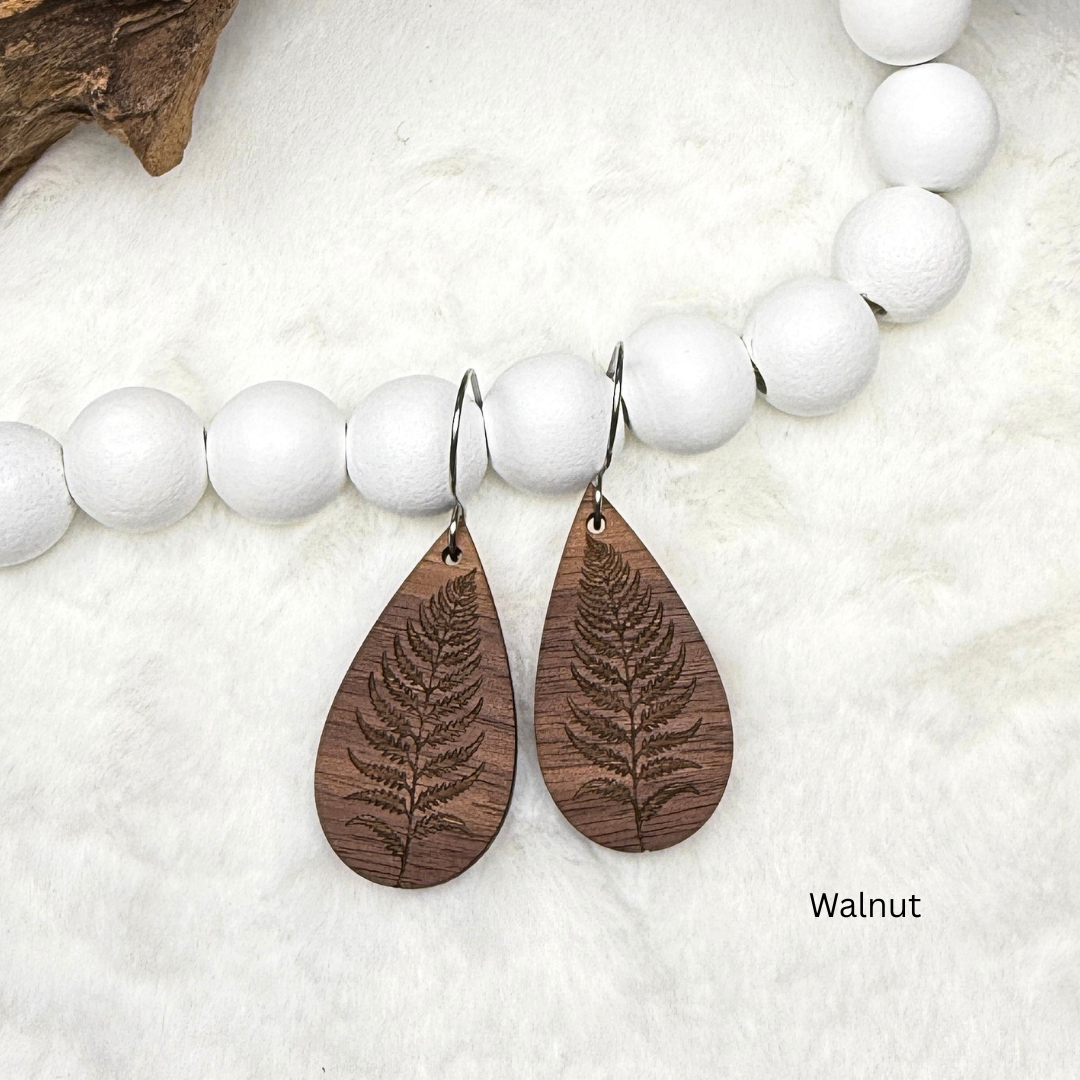 Fern leaf wooden earrings with stainless steel hooks. Finished with vegan wood oil. Laser engraved from walnut wood, handmade in Canada.