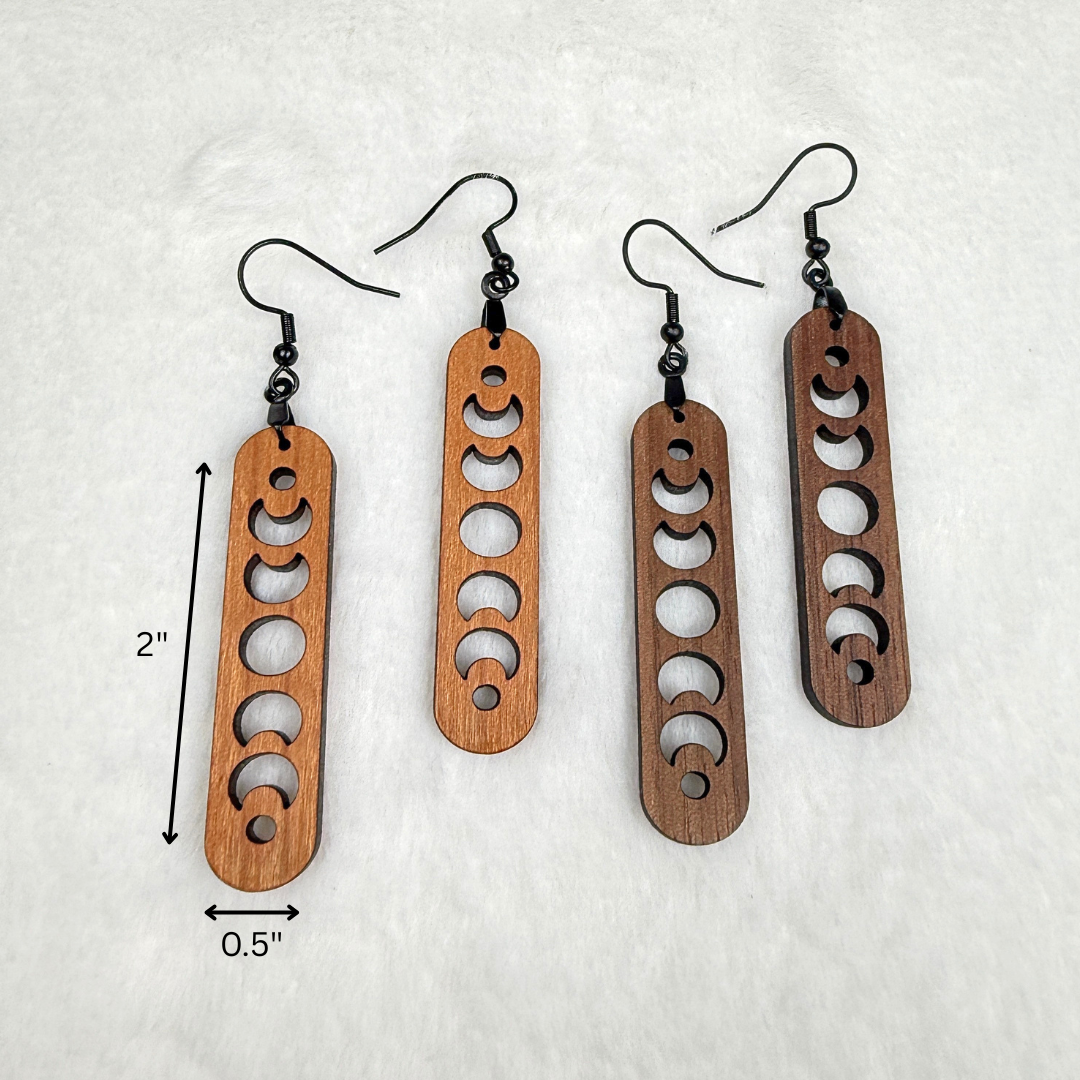 Wood earrings with laser cut crescent moon showing the measurements. Dangle earrings with black stainless steel hooks and silicone backers. Finished with natural wood oil.