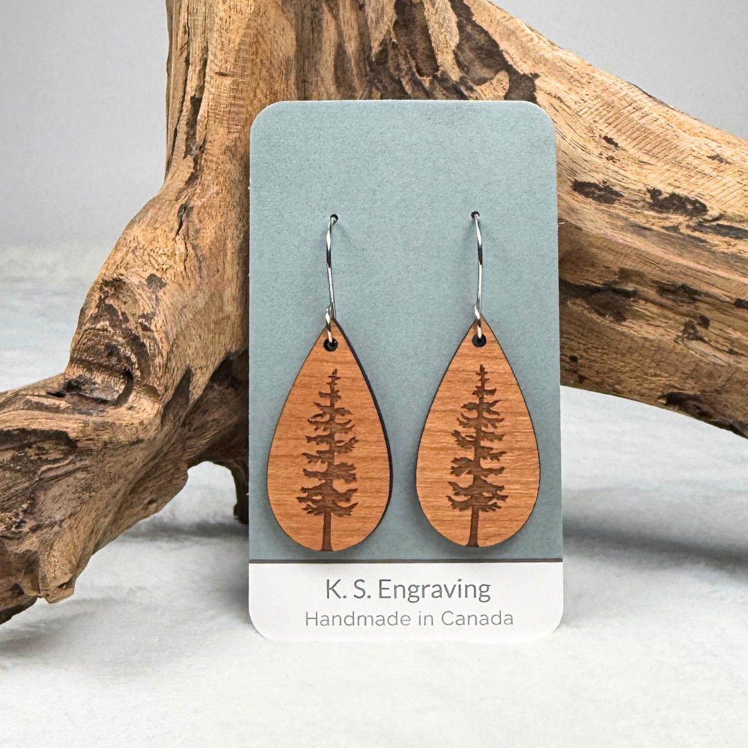 Teardrop shape wooden earrings with an engraved tree design made from cherry wood. Finished with vegan wood oil and stainless steel hooks. Hanging on K.S. Engraving display card.