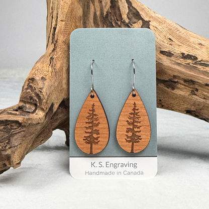 Teardrop shape wooden earrings with an engraved tree design made from cherry wood. Finished with vegan wood oil and stainless steel hooks. Hanging on K.S. Engraving display card.