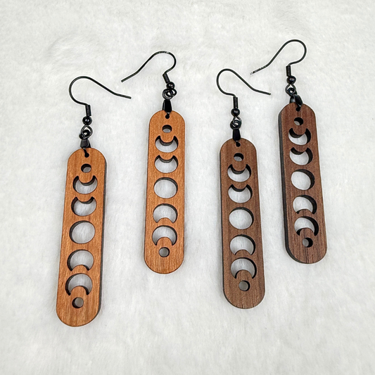 Wooden earrings with laser cut crescent moon. Dangle earrings with black stainless steel hooks and silicone backers. Finished with natural wood oil.